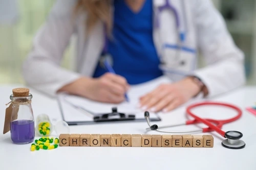 A chronic disease management doctor in Greenville, South Carolina, is shown with blocks that spell chronic disease.