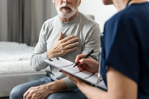 A senior patient with frequent health conditions talks to a Greenville physician about chronic disease treatment.