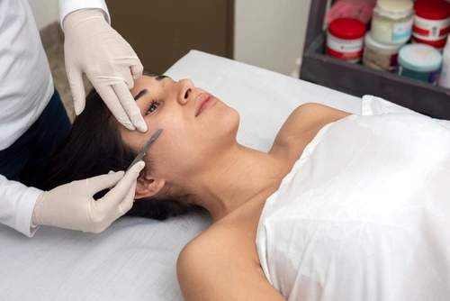 A young woman has a Greenville professional dermaplaning facial treatment for skin exfoliation.