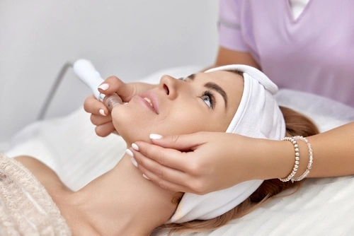 A woman receives a DiamondGlow dermalinfusion facial with microdermabrasion.