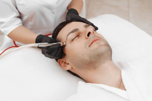 A man receives microdermabrasion treatment for exfoliation and healthy skin.
