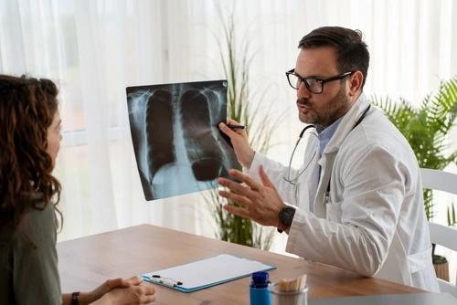 A doctor shows a chest x-ray to a patient after diagnostics and lab testing.